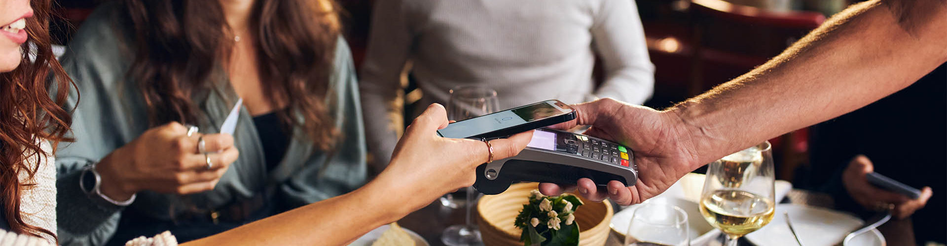 Friends paying contactlessly in restaurant Mobile ordering app for restaurant